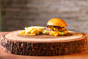 Tasty hamburger with fries.
homemade with lettuce and cheese, homemade meat on wooden table and rustic background.