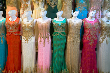 A display of colorful dresses in a market or store in Esfahan, Iran, showcasing vibrant fashion.