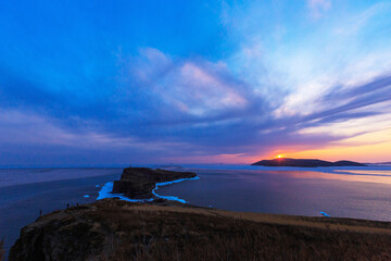 A picturesque sunset on the Russky Island in Vladivostok. The sun sets against the background of...