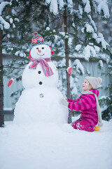Cute girl is making a snowman.