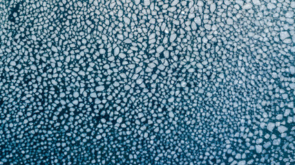 Arctic ice in the Sea of Japan. View from above. The ice was frozen on the sea with pancakes. - obrazy, fototapety, plakaty