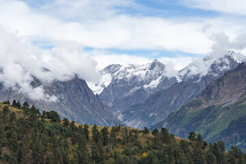 A breathtaking mountain landscape with snow-capped peaks under a clear blue sky, capturing the serene beauty and grandeur of nature.