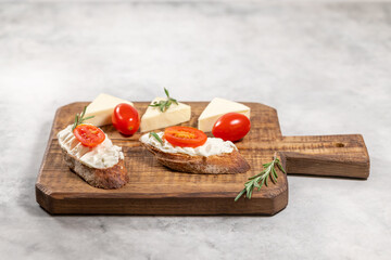 Cream cheese sandwiches with tomato and greens on wooden board, Christmas appetizer easy recipe