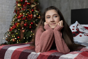 Beautiful young girl on the background of the Christmas interior.