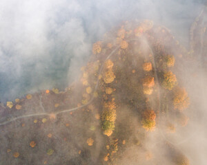 Aerial view of an autumn scene with foggy landscape and a lake