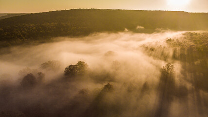 Aerial view of an autumn scene with foggy landscape and a lake