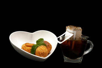 Brazilian food and drink balls cheese with mint served on heart-shaped bowl with mint American coffee filter
