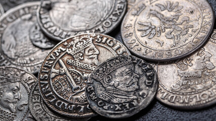 Closeup view of medieval European silver coins.Zygmunt III Waza.Ancient silver coins.Numismatics.silver coins covered in dirt.Antikvariat.