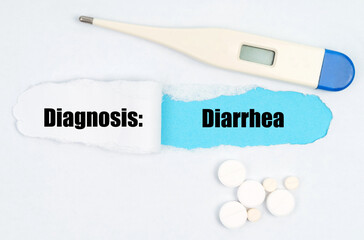 Medical diagnosis. On paper a thermometer, pills and a hole, inside which the inscription - Diarrhea