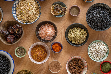 set of bowls with ingredients for fusion food recipes. Black beans, star anise, rice, chia and cocoa, star anise, black pepper, panela