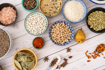 Image of ingredients inside pretty bowls viewed from the top on a white wood plank table with worn paint