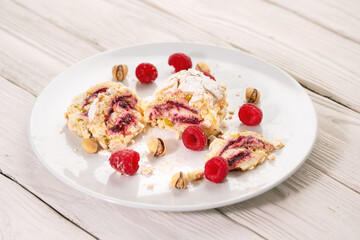 Tasty sweet roll cake with pistachios and raspberry on the plate