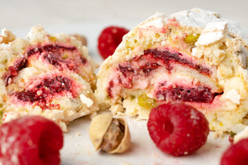 Close up of a sliced pistachio roll with fresh raspberries