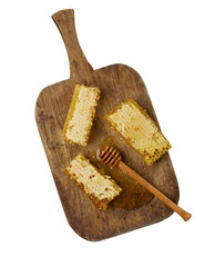 stack of wax honeycomb with honey on wooden board and wooden spoon, white isolated background