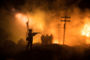 War Concept. Military silhouettes fighting scene on war fog sky background, World War Soldiers Silhouette Below Cloudy Skyline At night. Battle in ruined city. Selective focus