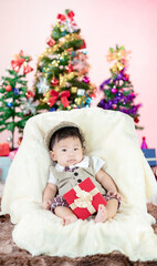 Obraz na płótnie Canvas Happy new year Christmas tree with Little baby sit on sofa.
