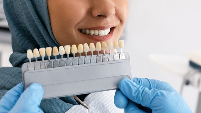 Dentist Holding Teeth Shade Chart Choosing Right Enamel Color For Muslim Patient