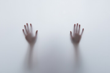 Shadow of hand behind the glass. Violence, fear, trapped and panic concept.