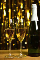 Champagne glasses on golden lights background. Happy new year or merry christmas