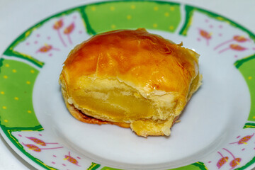 A type of croissant called bolen, served on a small plate, for breakfast or a menu with coffee, full of calories