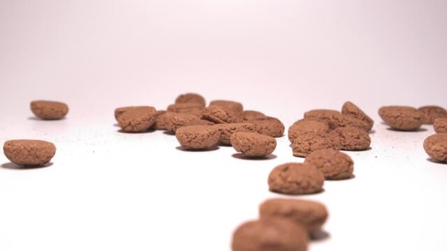 Traditional pepernoten falling on a white background. Slow motion.