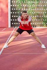 Fototapeta premium athletic man in red jersey on the sports ground exercise