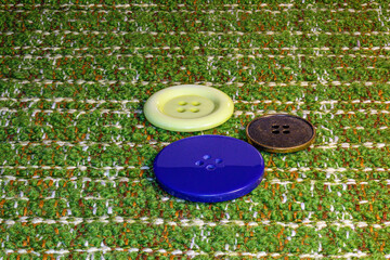 Buttons are different in color, shape, style, on a checkered fabric