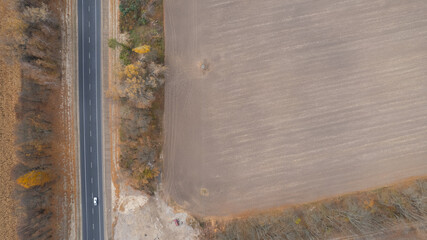 Autumn road near the corn field. Aerial view, drone shot