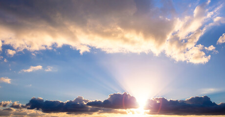 Panorama of the sky with clouds and lit by the light of the sunset.