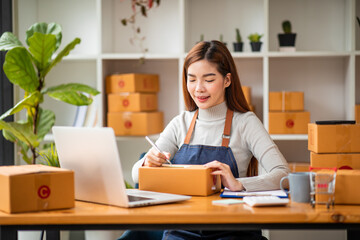 Portrait of Starting small businesses SME owners female entrepreneurs working on receipt box and check online orders to prepare to pack the boxes, sell to customers, sme business ideas online.