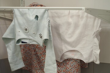 Clothes hanging on the dryer, baby clothes.