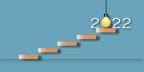 Stair with light bulb in the year 2022 on blue background. Concept for innovative business vision or resolution, new ideas and innovation. Space for the text. Paper art design style.