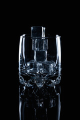 Empty glass filled with ice cubes o na black background