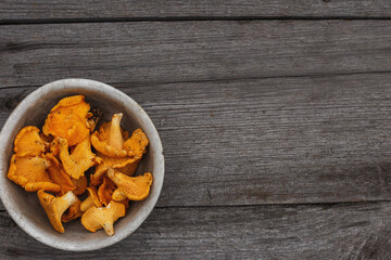chanterelles in a bowl on an old wooden table, flat lay