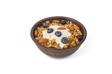 Deep clay bowl with muesli and yogurt isolated on a white background.