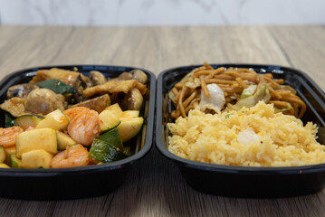 Chinese fast food combination meal with fried rice, chow mein, stir fry zucchini, shrimp, and mushrooms for a very hearty meal.