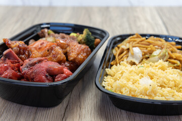 Chinese fast food combination meal with fried rice, chow mein, chicken, and BBQ spare ribs for a...