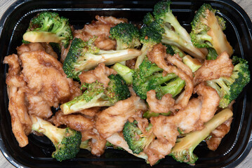 Overhead view of delicious bowl of broccoli and chicken blended for a specially seasoned Chinese fast food meal.