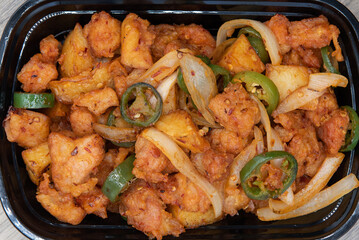 Overhead view of jalapeno peppers chopped over the pepper seasoned potatoes for a delicious spicy dish.