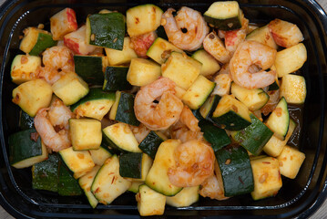 Overhead view of crabmeat, zucchini, and shrimp are all seasoned perfectly into this stir fry dish for a meal.
