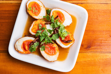 Top view fried boil chicken eggs with tamarind sauce, topped with dried chili and coriander. The food is called Kai-Loog-Keay in Thai language, the menu means son-in-law's egg.