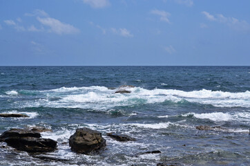 View from the rocky coast to the sea on a sunny day