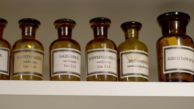 Pan shot of old german drugstore and chemical laboratory bottles with different chemicals - close up pro res 