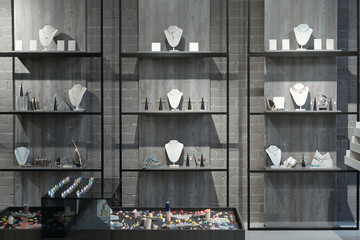 Part of interior of luxury jewelry store or gift shop with necklaces, bracelets, rings and earrings...