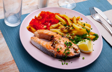 Spanish cuisine, roasted seafood salmon with fried potato and pepper on a ceramic plate