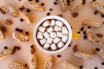 Flat lay on cup with black coffee with marshmallows and cookies cantuccini, decorated almond and coffee beans on pink background.