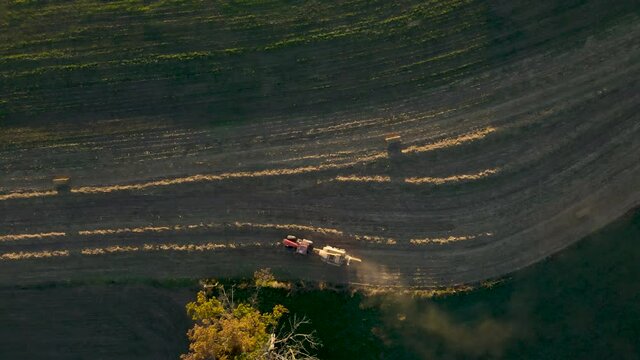 Top-Down Aerial Of Tractor Baling Corn And Kicking Up Dust Late In Season In Pennsylvania, U.S.A., Farmland