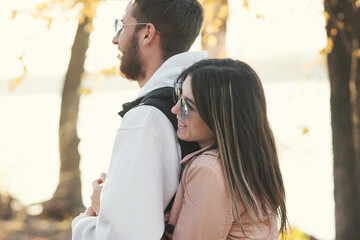 Outdoor shot young loving couple walking. Lovers posing in autumn leaves forest background. Concept of youth, love and lifestyle. Authentic real people portrait. Candid portrait.