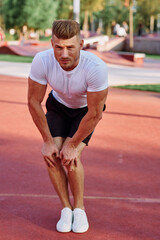 Fototapeta premium man in white t-shirt on the sports ground workout motivation