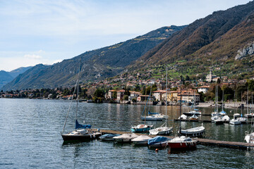 Fototapeta na wymiar Pier with moored yachts near the town. Lake Como, Italy
